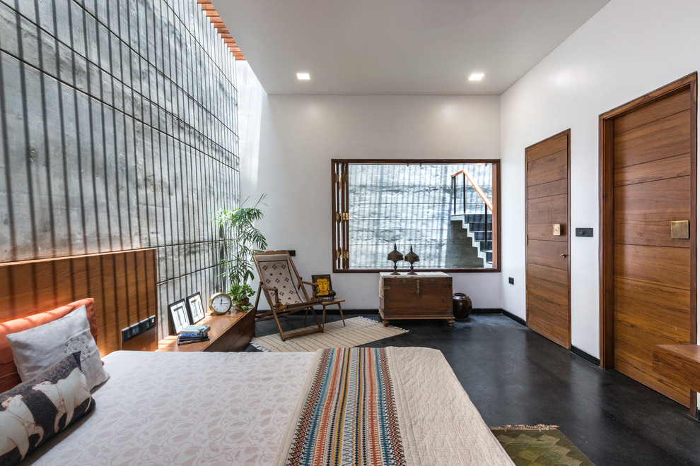 This is an example of a large asian guest bedroom in Other with white walls, concrete floors and grey floor.