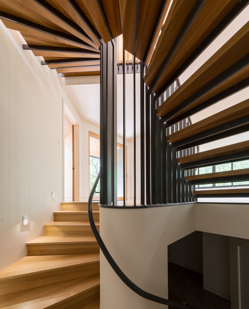 This is an example of a mid-sized contemporary wood u-shaped staircase in Denver with open risers and metal railing.