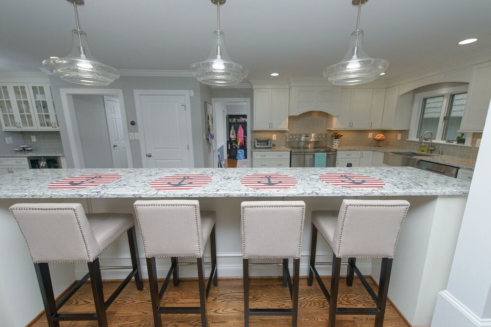Eat-in kitchen - transitional l-shaped medium tone wood floor eat-in kitchen idea in Baltimore with a farmhouse sink, beaded inset cabinets, white cabinets, granite countertops, gray backsplash, glass tile backsplash, stainless steel appliances and an island