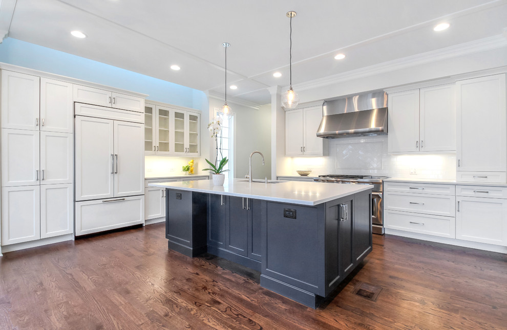 Example of a large transitional l-shaped dark wood floor open concept kitchen design in Chicago with quartz countertops, white backsplash, paneled appliances, an island, a double-bowl sink, shaker cabinets, subway tile backsplash and white cabinets