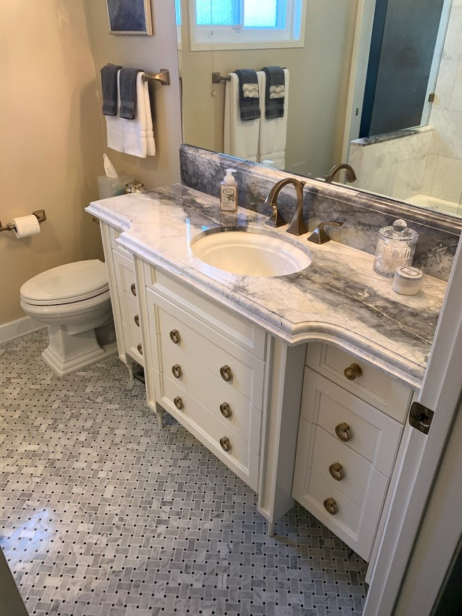 Medium sized traditional ensuite bathroom in Los Angeles with freestanding cabinets, white cabinets, a built-in bath, a shower/bath combination, a two-piece toilet, white tiles, marble tiles, beige walls, marble flooring, a submerged sink, marble worktops, multi-coloured floors, an open shower, multi-coloured worktops and a single sink.