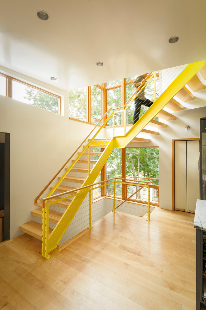 This is an example of a contemporary wood l-shaped staircase in Boston with open risers and cable railing.