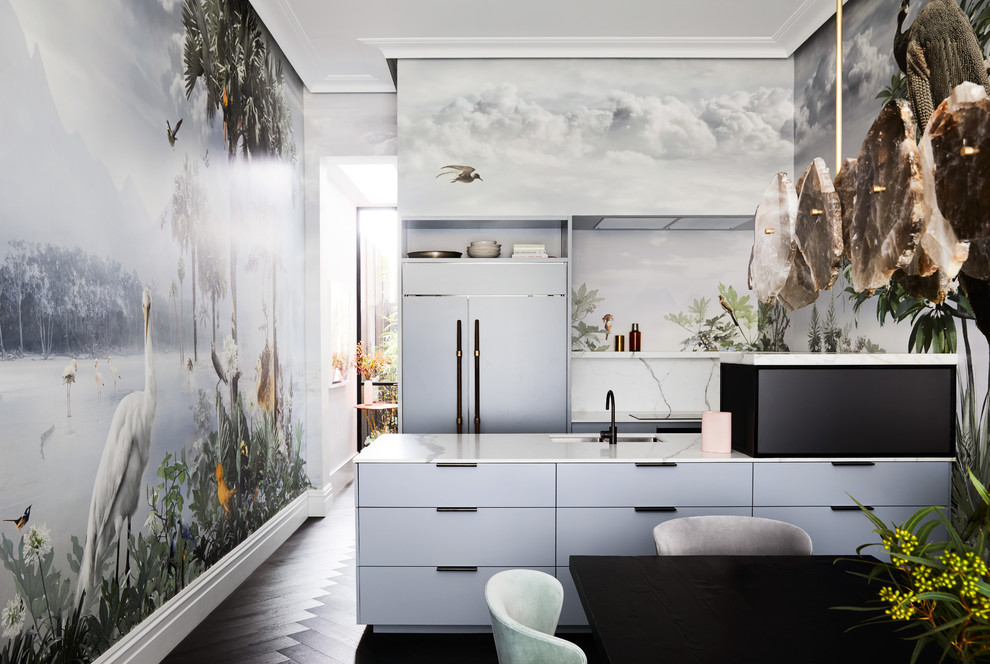 This is an example of an eclectic galley kitchen in Melbourne with an undermount sink, flat-panel cabinets, grey cabinets, panelled appliances, dark hardwood floors, a peninsula, black floor and white benchtop.
