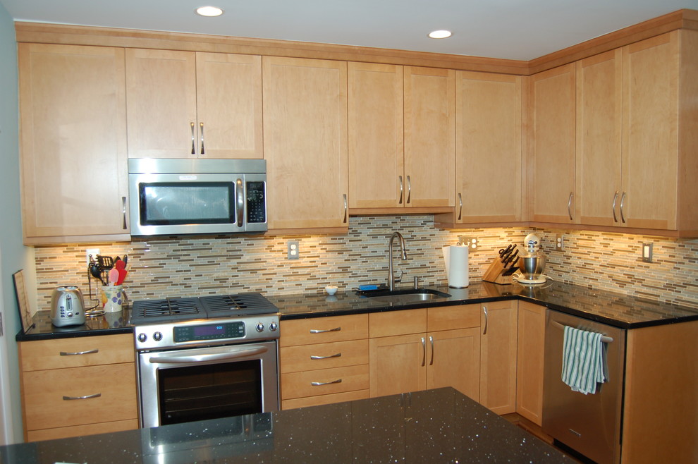 Inspiration for a mid-sized transitional medium tone wood floor enclosed kitchen remodel in DC Metro with an undermount sink, flat-panel cabinets, light wood cabinets, glass tile backsplash, stainless steel appliances and an island