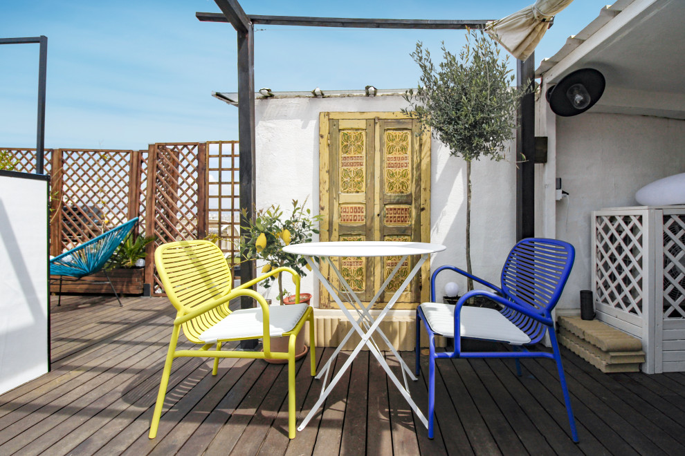 This is an example of a mid-sized mediterranean deck in Marseille with a pergola.