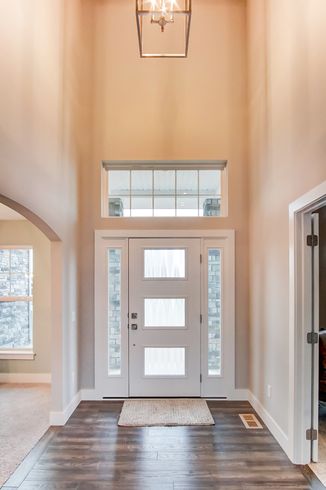 Inspiration for a mid-sized transitional dark wood floor and brown floor front door remodel with beige walls and a white front door