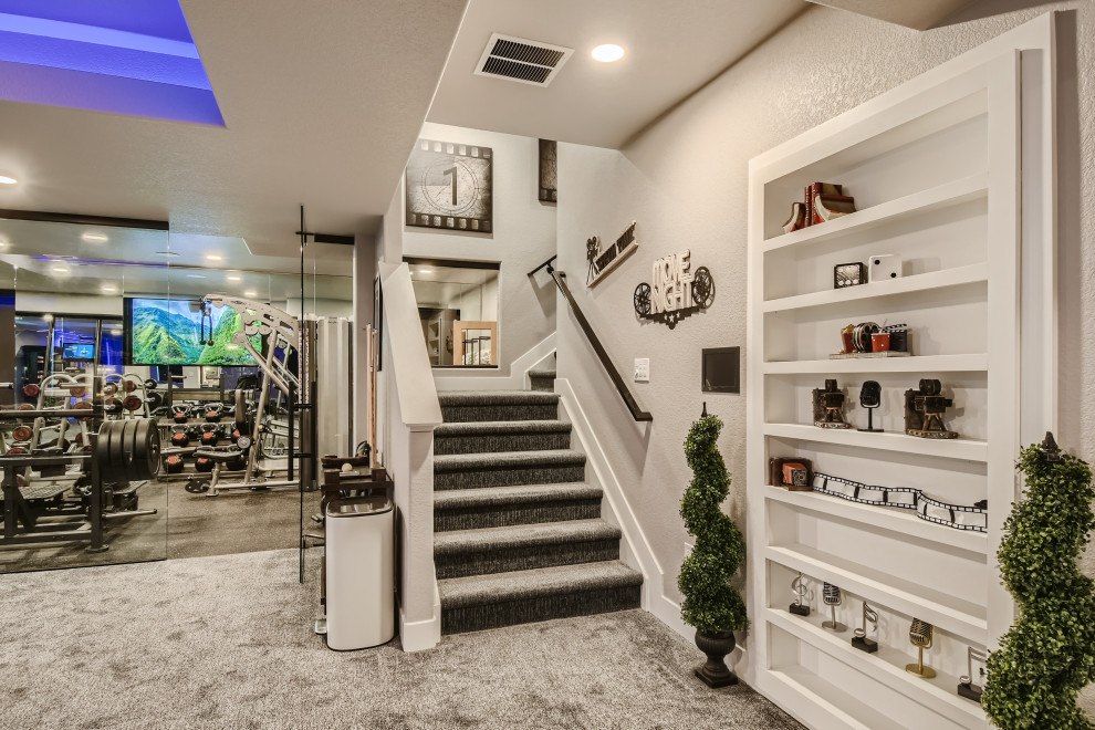 This is an example of a large modern basement in Denver with a game room, grey walls, carpet, a ribbon fireplace, a wood fireplace surround, grey floor and coffered.