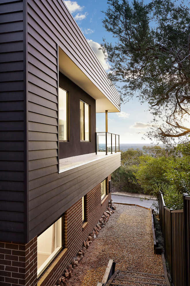 Design ideas for a large modern two-storey brown exterior in Melbourne with mixed siding and a flat roof.