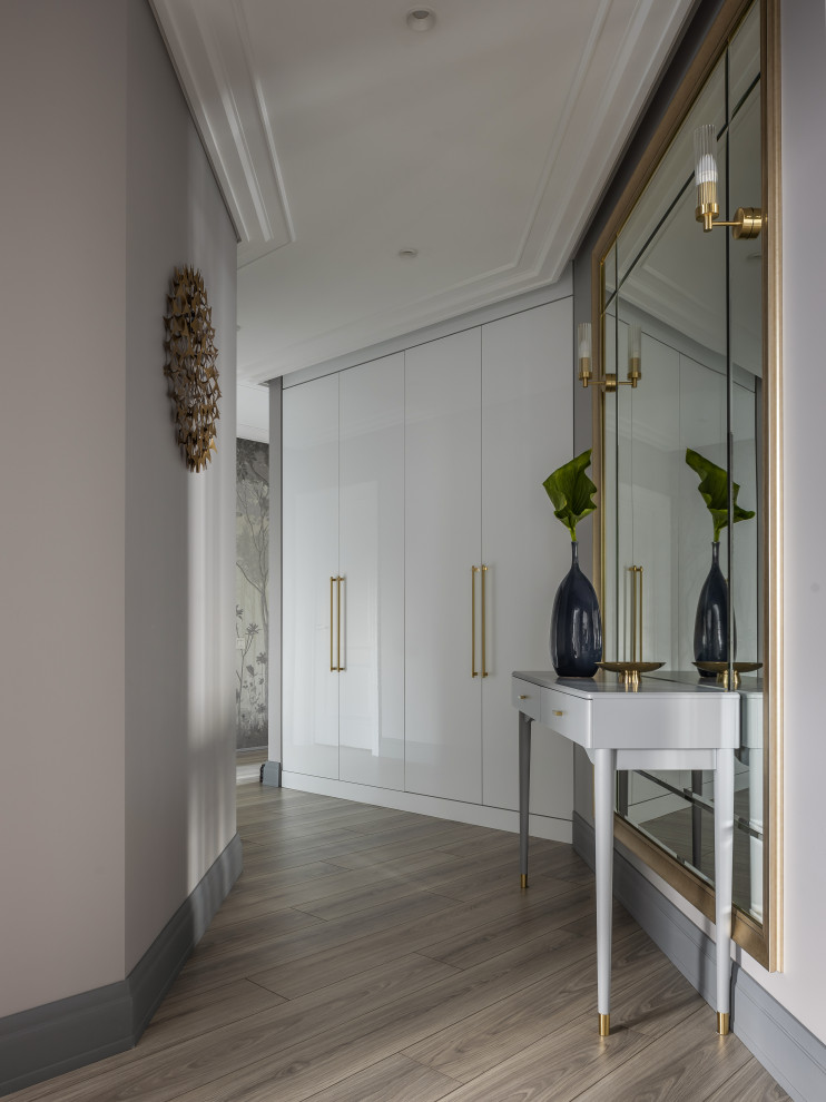 Idée de décoration pour un couloir design de taille moyenne avec un mur gris, sol en stratifié et un sol beige.