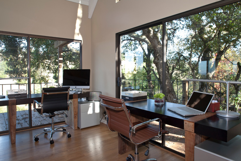 Modern home office in San Francisco with beige walls, medium hardwood floors and a freestanding desk.