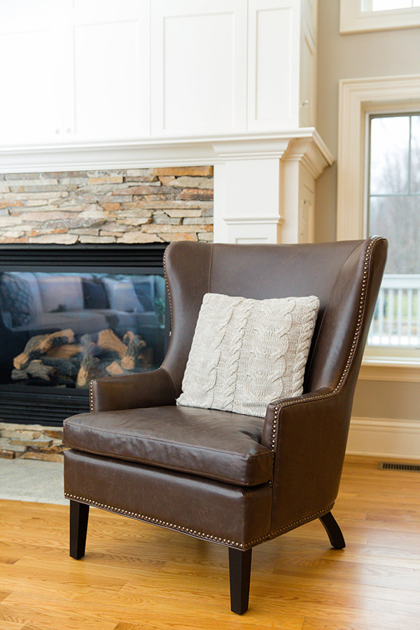 Transitional living room in Columbus with grey walls, a standard fireplace, a brick fireplace surround and brown floor.