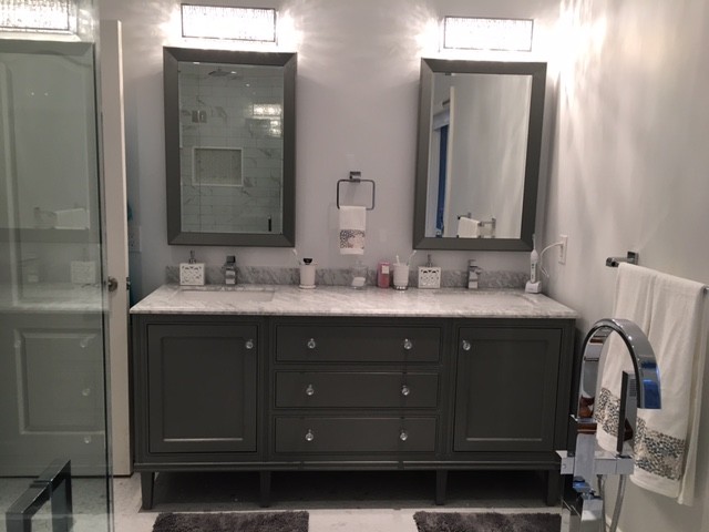 Photo of a mid-sized transitional master bathroom in Toronto with shaker cabinets, grey cabinets, marble benchtops, a freestanding tub, a corner shower, a one-piece toilet, white tile, stone tile, grey walls, marble floors, an undermount sink, white floor and a hinged shower door.