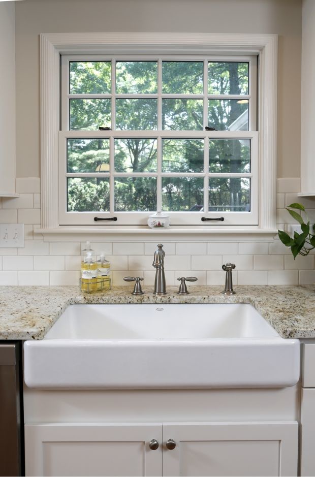 Eat-in kitchen - mid-sized transitional l-shaped dark wood floor eat-in kitchen idea in Cedar Rapids with a farmhouse sink, shaker cabinets, white cabinets, granite countertops, white backsplash, subway tile backsplash, stainless steel appliances and an island