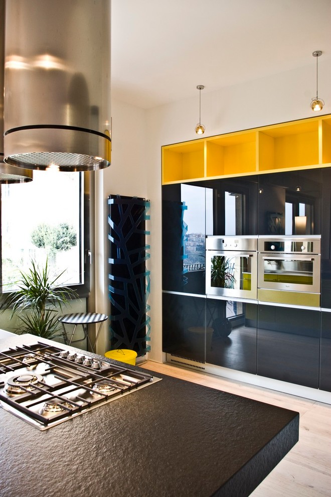 Inspiration for a small contemporary galley eat-in kitchen in Naples with a drop-in sink, glass-front cabinets, yellow cabinets, limestone benchtops, yellow splashback, glass sheet splashback, coloured appliances, light hardwood floors and with island.