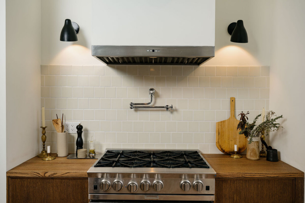 This is an example of a small retro kitchen in New York with white splashback and ceramic splashback.