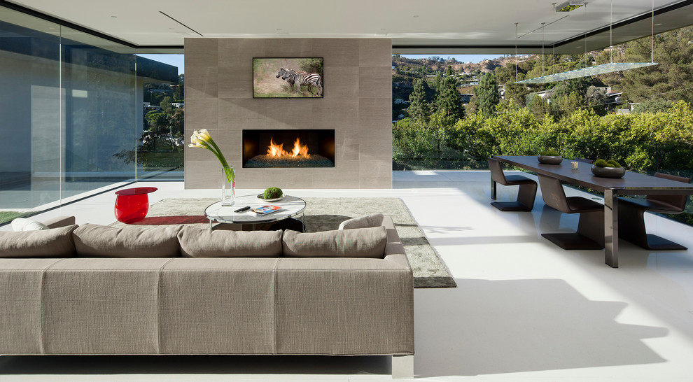 This is an example of a modern living room in Los Angeles with a ribbon fireplace, a tile fireplace surround and a wall-mounted tv.