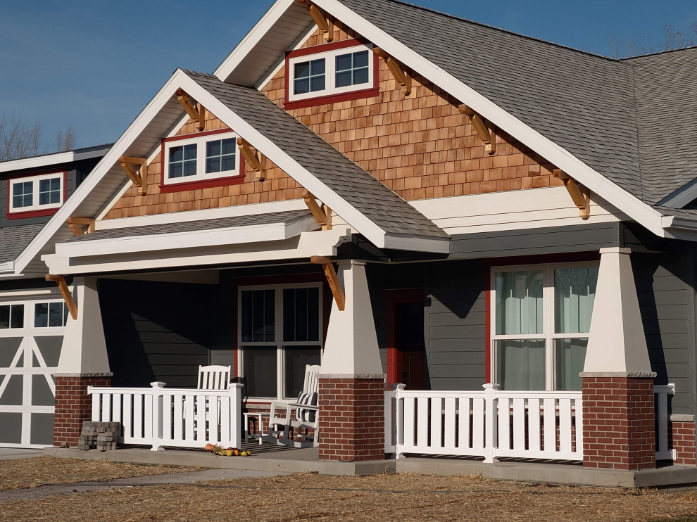 Cette image montre une grande façade de maison grise craftsman en bois et bardage à clin de plain-pied avec un toit à deux pans, un toit en shingle et un toit gris.