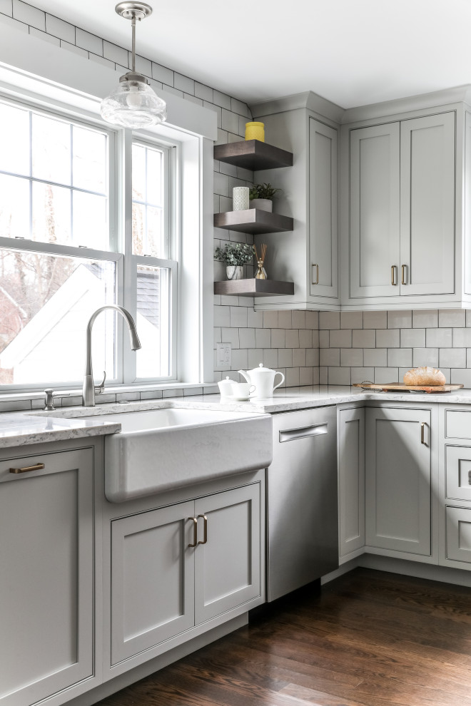 Eat-in kitchen - transitional l-shaped medium tone wood floor and brown floor eat-in kitchen idea in Boston with a farmhouse sink, beaded inset cabinets, white cabinets, quartz countertops, white backsplash, subway tile backsplash, stainless steel appliances, an island and gray countertops