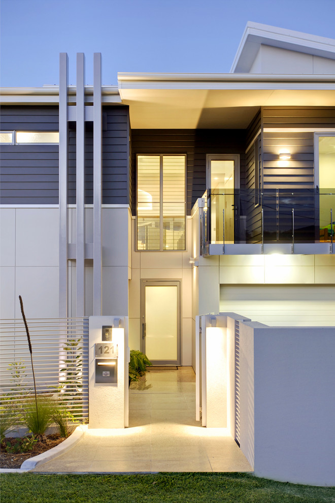 Photo of a large contemporary three-storey grey house exterior in Brisbane with concrete fiberboard siding, a metal roof and a flat roof.
