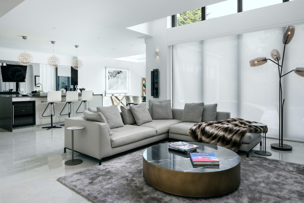This is an example of a large contemporary open concept living room in Essex with marble floors, a wall-mounted tv, white walls and white floor.