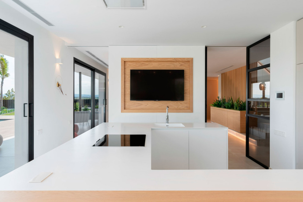 Example of a minimalist open concept kitchen design in Valencia with flat-panel cabinets