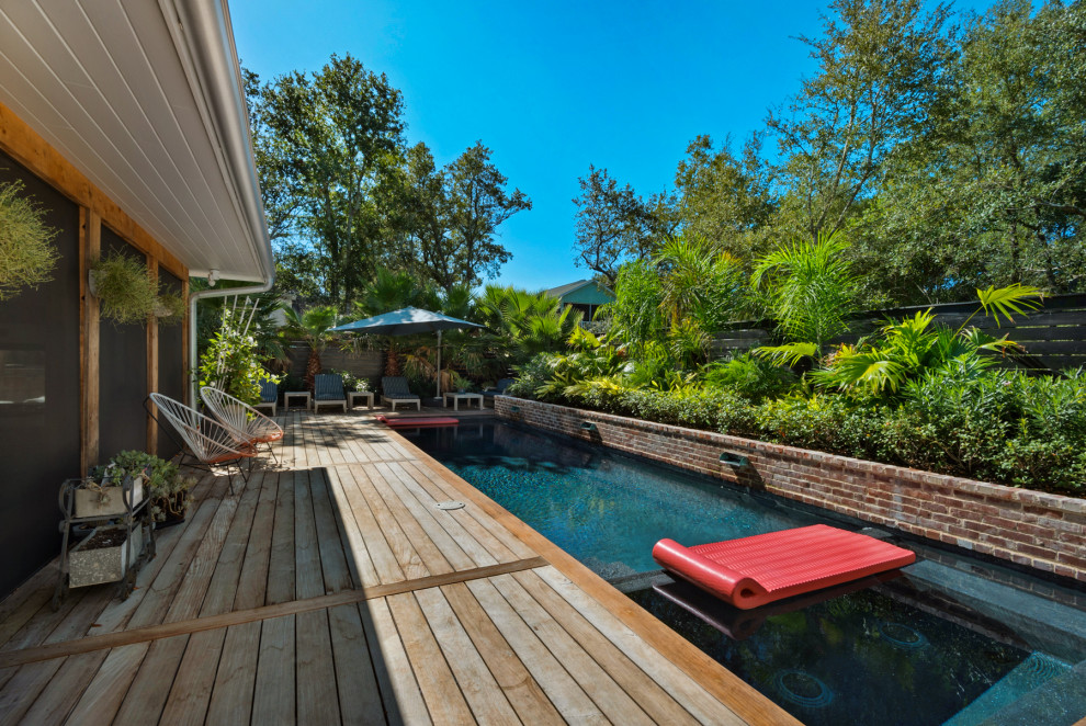 Design ideas for a small tropical side yard rectangular pool in Miami with decking.