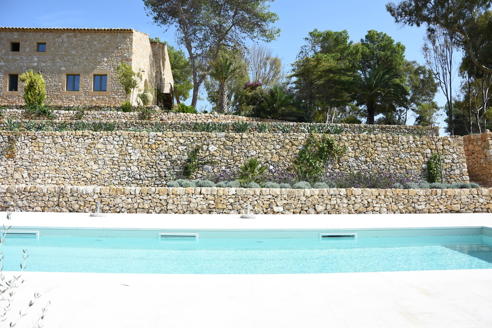 Foto di una piscina country rettangolare di medie dimensioni e nel cortile laterale con pavimentazioni in pietra naturale