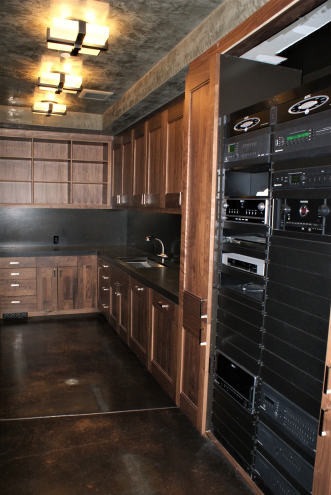 This is an example of a large arts and crafts u-shaped utility room in Denver with an undermount sink, concrete floors, flat-panel cabinets, dark wood cabinets, concrete benchtops, grey walls and a side-by-side washer and dryer.
