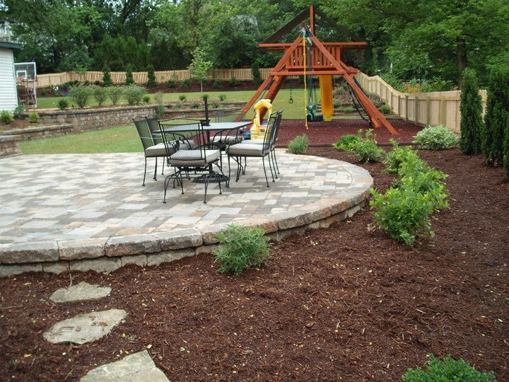 Large transitional backyard garden in St Louis with concrete pavers and with outdoor playset.