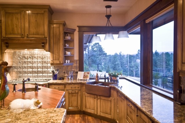 Eat-in kitchen - huge rustic u-shaped medium tone wood floor eat-in kitchen idea in Phoenix with a farmhouse sink, raised-panel cabinets, medium tone wood cabinets, granite countertops, beige backsplash, mosaic tile backsplash, stainless steel appliances and an island