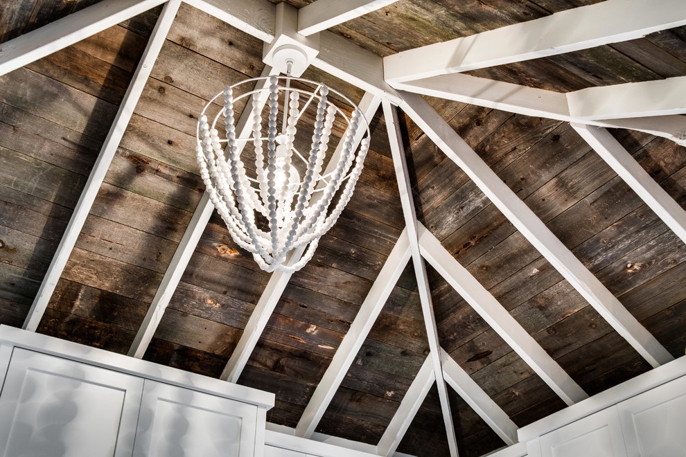 Inspiration for a mid-sized rustic u-shaped light wood floor eat-in kitchen remodel in Boise with a drop-in sink, flat-panel cabinets, white cabinets, stainless steel appliances and no island