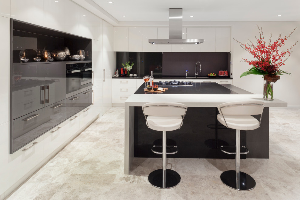 Design ideas for a large contemporary l-shaped eat-in kitchen in Perth with a double-bowl sink, quartz benchtops, black splashback, stone slab splashback, panelled appliances, limestone floors, with island and flat-panel cabinets.