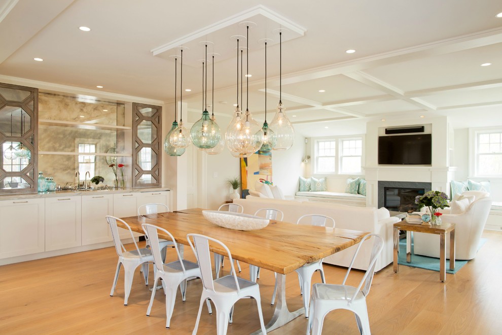 Inspiration for a mid-sized beach style open plan dining in Boston with white walls, medium hardwood floors, a standard fireplace and a stone fireplace surround.