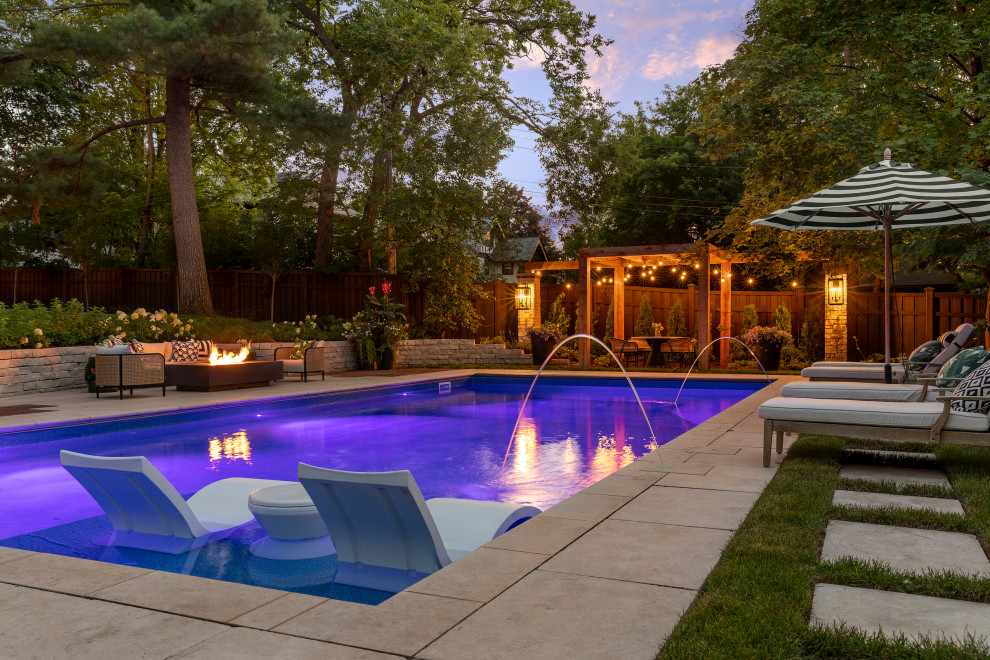 Idée de décoration pour un grand piscine avec aménagement paysager arrière craftsman rectangle avec des pavés en pierre naturelle.