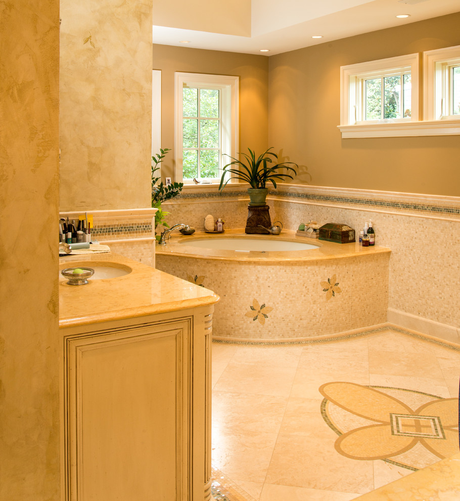 Photo of a large traditional master bathroom in DC Metro with raised-panel cabinets, light wood cabinets, an undermount tub, an alcove shower, a one-piece toilet, white tile, ceramic tile, beige walls, ceramic floors, an undermount sink and marble benchtops.
