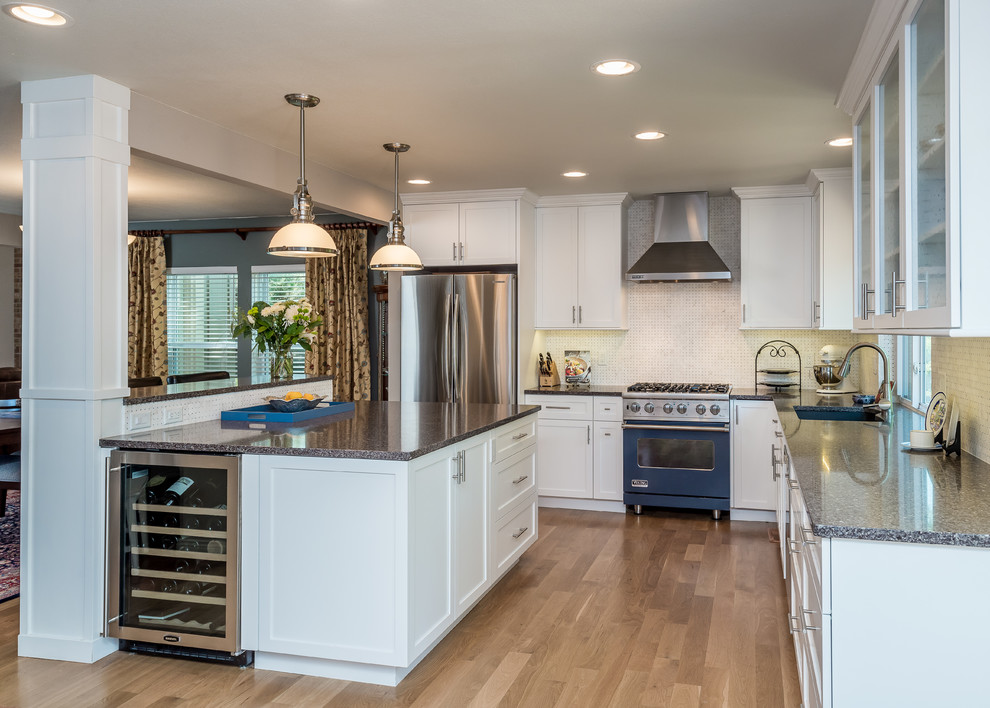 Example of a mid-sized transitional l-shaped eat-in kitchen design in Denver with shaker cabinets, white cabinets, quartz countertops, white backsplash, colored appliances and an island