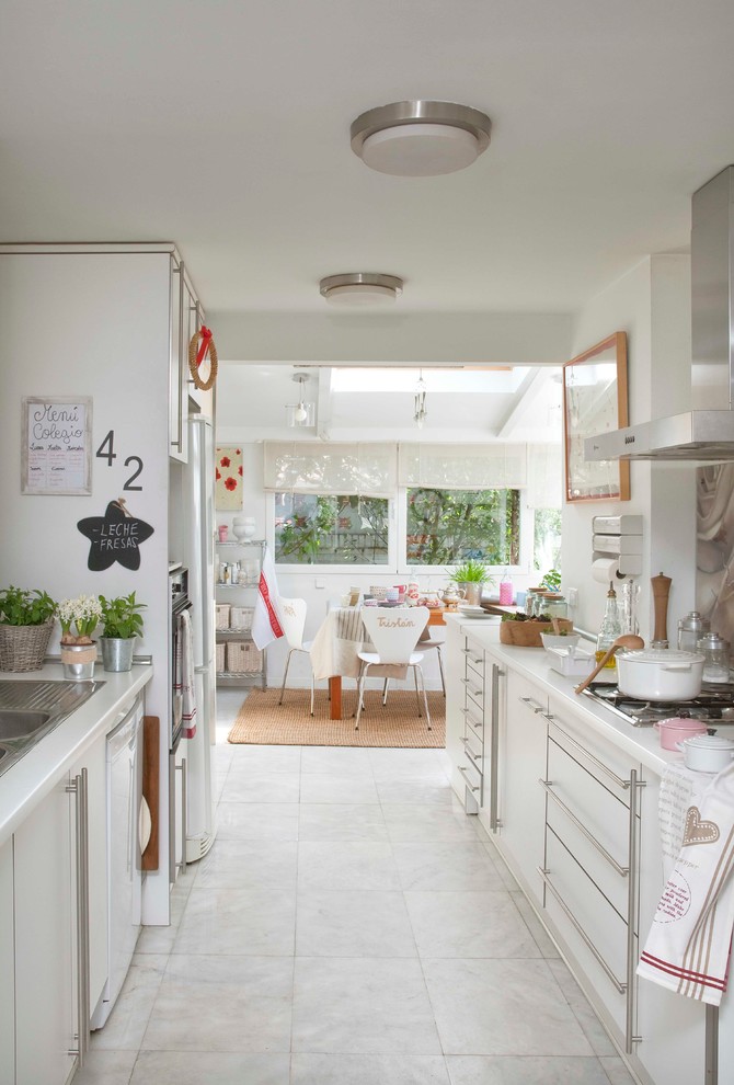Inspiration for a large contemporary galley eat-in kitchen in Madrid with flat-panel cabinets, white cabinets, no island, white floor and white benchtop.