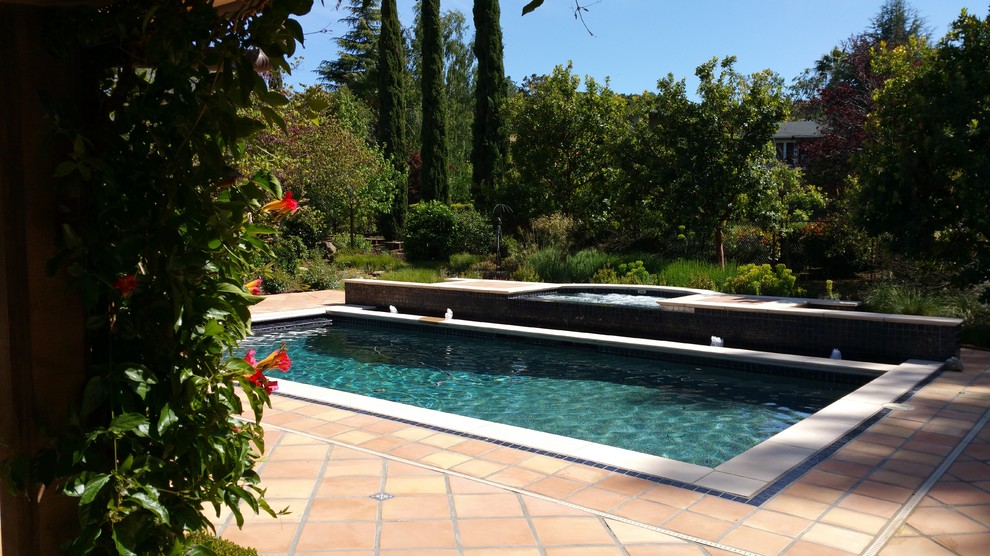 Mid-sized mediterranean backyard rectangular lap pool in San Francisco with a water feature and tile.