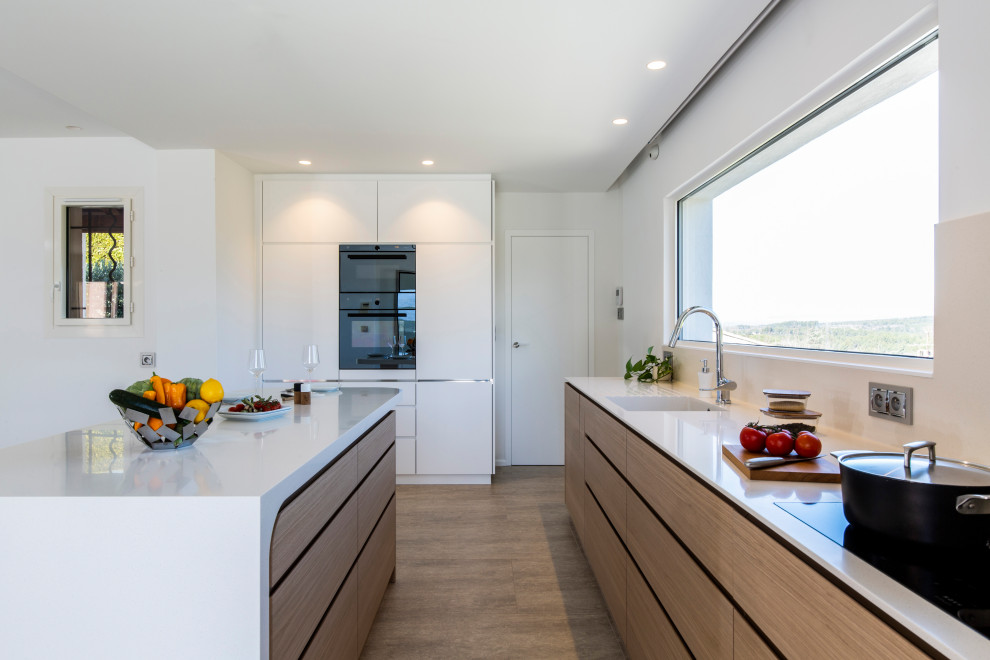 Inspiration for a large contemporary l-shaped kitchen in Frankfurt with an integrated sink, flat-panel cabinets, light wood cabinets, beige splashback, porcelain splashback, panelled appliances, with island, beige floor and white benchtop.