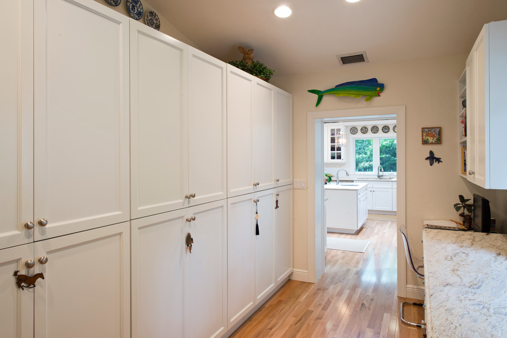 Example of a transitional eat-in kitchen design in Miami with an undermount sink, white cabinets, white backsplash and stainless steel appliances