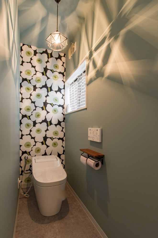 Photo of a small scandinavian powder room in Other with green walls, vinyl floors, brown floor, wallpaper and wallpaper.