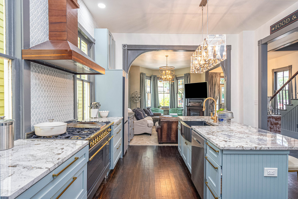 Kitchen pantry - large transitional galley dark wood floor and black floor kitchen pantry idea with a farmhouse sink, shaker cabinets, blue cabinets, granite countertops, blue backsplash, ceramic backsplash, black appliances, an island and white countertops