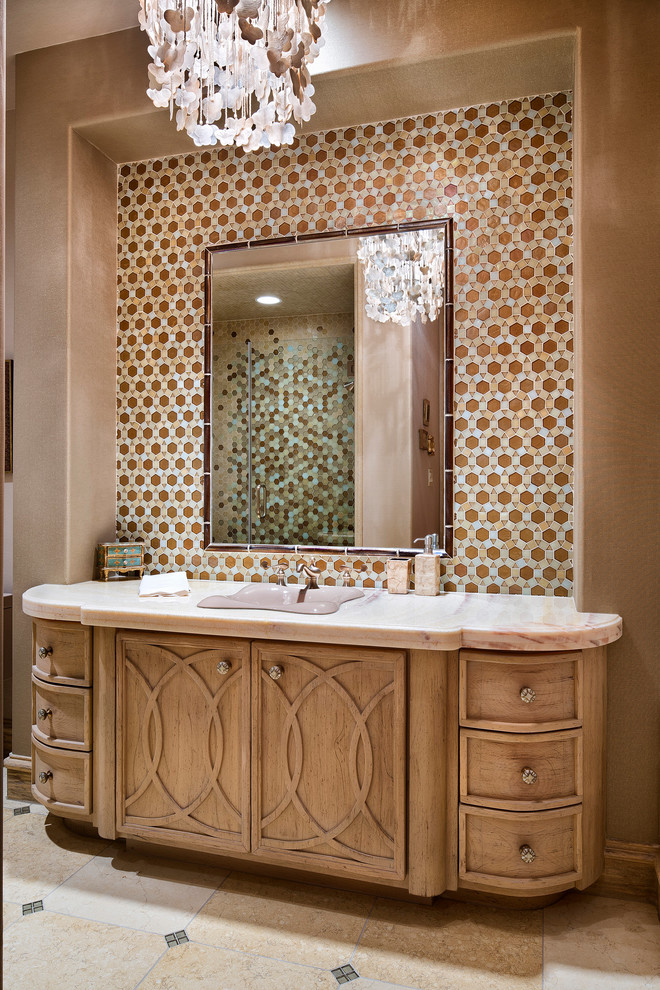 Design ideas for a mid-sized mediterranean bathroom in Houston with recessed-panel cabinets, light wood cabinets, multi-coloured tile, mosaic tile, multi-coloured walls, beige floor, an alcove shower, a drop-in sink, a hinged shower door and pink benchtops.