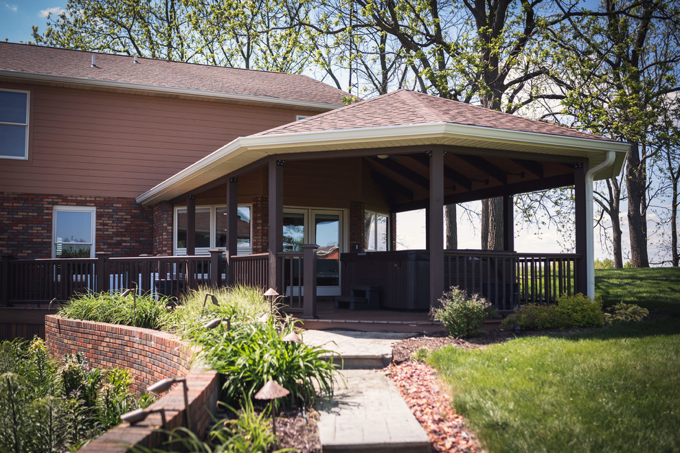 Huge mountain style backyard outdoor kitchen deck photo in Indianapolis with a roof extension
