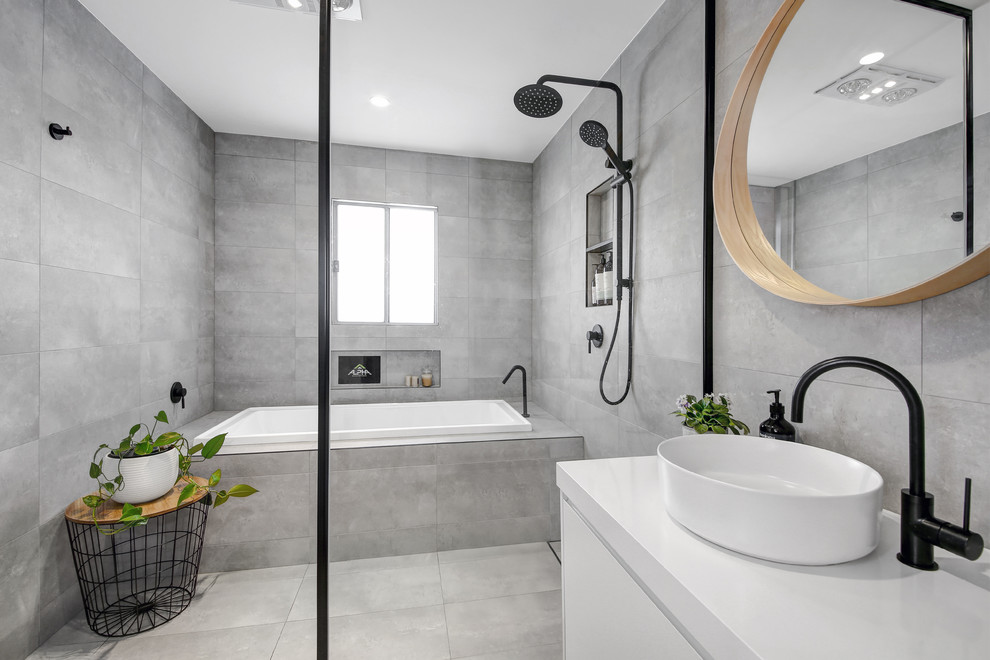 Inspiration for a mid-sized contemporary master wet room bathroom in Sydney with flat-panel cabinets, white cabinets, a drop-in tub, porcelain tile, grey walls, porcelain floors, grey floor, an open shower, gray tile, a vessel sink and white benchtops.