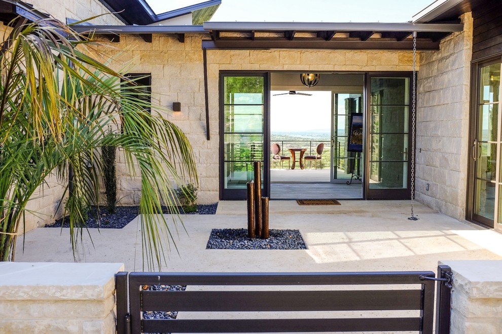 This is an example of a modern one-storey beige exterior in Austin with stone veneer.