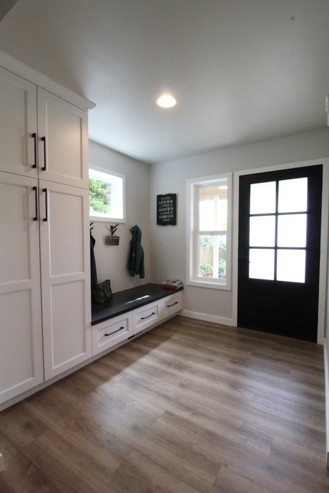 This is an example of a medium sized classic foyer in Seattle with grey walls, vinyl flooring, a single front door, a black front door and brown floors.