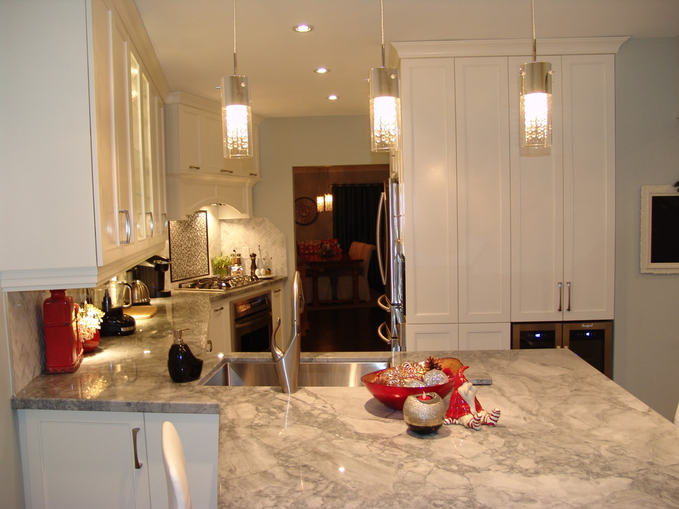 Photo of a mid-sized transitional galley eat-in kitchen in Toronto with an undermount sink, shaker cabinets, white cabinets, quartzite benchtops, white splashback, stone tile splashback, stainless steel appliances, medium hardwood floors and a peninsula.