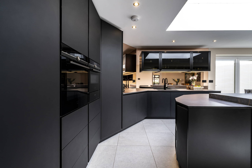 Photo of a medium sized modern kitchen/diner in Oxfordshire with an integrated sink, glass-front cabinets, black cabinets, quartz worktops, glass sheet splashback, black appliances, ceramic flooring, an island, grey floors, multicoloured worktops, a coffered ceiling and feature lighting.