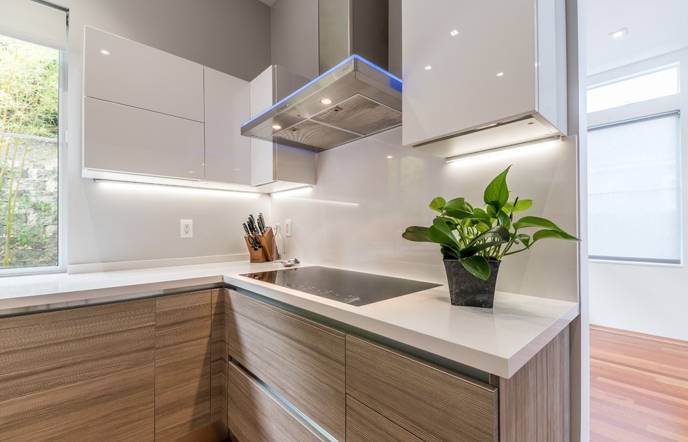 Photo of a mid-sized modern u-shaped eat-in kitchen in San Francisco with an undermount sink, flat-panel cabinets, medium wood cabinets, quartz benchtops, stainless steel appliances, dark hardwood floors, a peninsula and brown floor.